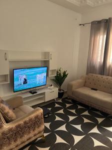 Una sala de estar con un sofá y un televisor de pantalla plana. en Kisal Immoble, en Dakar
