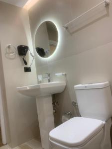 a bathroom with a toilet and a sink and a mirror at Manga guesthouse in Gjirokastër