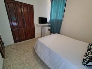 a small bedroom with a bed and a television at Private and comfortable double room in Santo Domingo +17 photos