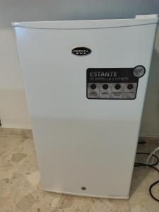 a white refrigerator with a sign on it at Private and comfortable double room in Santo Domingo