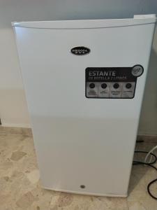 a white refrigerator with a sign on it at Private and comfortable double room in Santo Domingo