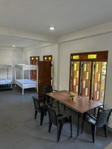 シギリヤにあるVibra Hostelの木製のテーブルと椅子、ベッドが備わる客室です。