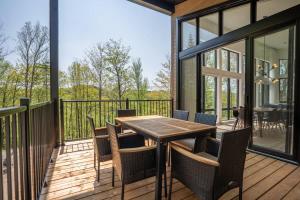 a patio with a wooden table and chairs on a deck at Chalet du Golf avec Spa in Saint-Faustin +27 photos
