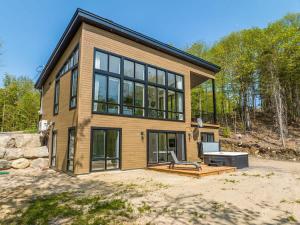 a large house with a bench in front of it at Chalet du Golf avec Spa in Saint-Faustin