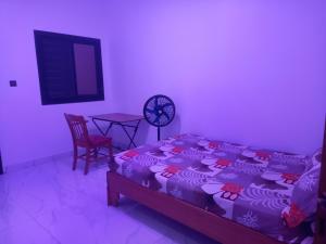 a bedroom with a bed and a table with a chair at Femi in Dakar