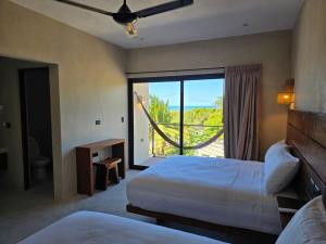 Una habitación de hotel con dos camas y una gran ventana. en Luumbal El Cuyo, en El Cuyo 75 fotos más