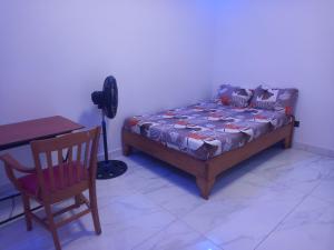 a bedroom with a bed and a desk and a chair at Femi in Dakar