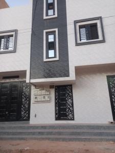 a white building with black doors and windows at Femi in Dakar