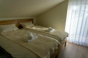 Kuća za odmor Back to Bašić في Mandičevac: سريرين وعليهم مناشف في غرفة النوم