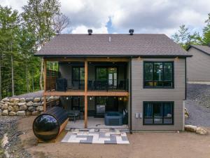 a large house with a large deck and a largearton at Le Birdie spa et sauna in Saint-Faustin