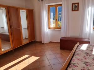 a bedroom with a bed and a dresser and a window at Casa della Nonna in Celledizzo