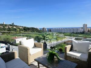 balcone con sedie in vimini e tavolo con vista. di Elegant Duplex Penthouse A116 a Las Lagunas Mijas