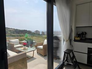 un soggiorno con balcone affacciato sull'oceano di Elegant Duplex Penthouse A116 a Las Lagunas Mijas