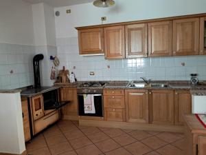 a kitchen with wooden cabinets and a stove top oven at Casa della Nonna in Celledizzo +3 photos