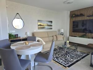 un soggiorno con un divano, un tavolo e delle sedie di Elegant Duplex Penthouse A116 a Las Lagunas Mijas