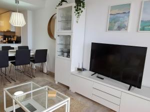 een woonkamer met een grote flatscreen-tv bij Duplex Penthouse With 4 Bedrooms in Arroyo de la Miel