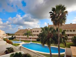 een uitzicht op een resort met een zwembad en palmbomen bij Duplex Penthouse With 4 Bedrooms in Arroyo de la Miel