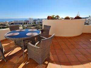 een terras met een tafel en stoelen op een balkon bij Duplex Penthouse With 4 Bedrooms in Arroyo de la Miel
