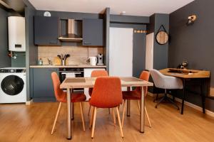 une cuisine et une salle à manger avec une table et des chaises dans l'établissement Studio 104 le Graphite - Modern & Elegant, à Bertrange 3 autres photos