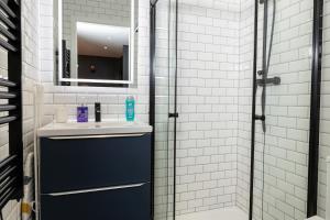 une salle de bain avec lavabo et douche dans l'établissement Studio 104 le Graphite - Modern & Elegant, à Bertrange