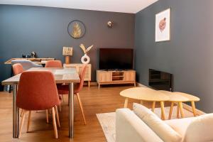 un salon avec une table, des chaises et une télévision dans l'établissement Studio 104 le Graphite - Modern & Elegant, à Bertrange
