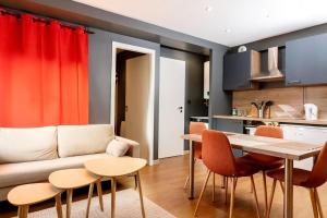 a living room with a couch and a table and chairs at Studio 104 le Graphite - Modern & Elegant in Bertrange