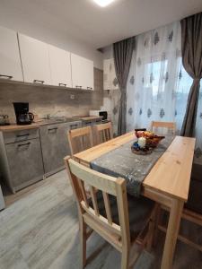 a kitchen with a wooden table with chairs and a tableasteryasteryasteryasteryastery at Apartment Premium in Topliţa