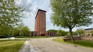 豪滕豪滕凡德瓦克酒店的道路一侧高大的红色建筑