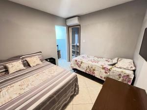 a hotel room with two beds and a balcony at Kitnet a 1 Km da Orla in Aracaju