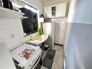 a small kitchen with a sink and a refrigerator at Kitnet a 1 Km da Orla in Aracaju