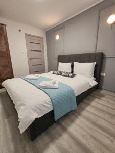 a bedroom with a large bed with two towels on it at Apartment Premium in Topliţa