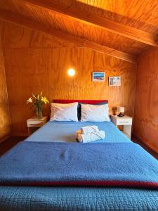 a bedroom with a blue bed with a stuffed animal on it at Hotel Gran Luna in Puerto Montt +28 photos