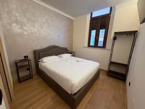 a bedroom with a bed with white sheets and a window at Le Stanze Del Duca in Ferrara