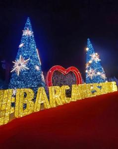 a christmas tree and a sign with the word happy at La plage du Lido in Le Barcarès