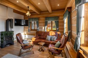 een woonkamer met een bank, stoelen en een fornuis bij Dřevěnka pod strání in Cerny Dul
