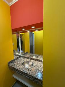 een badkamer met een wastafel voor een spiegel bij Sendero Patagonico in Las Grutas