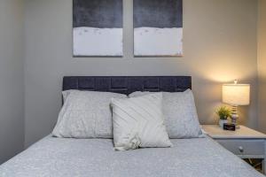 Charming 2 Bedroom Home by Founder's Park في جونسون سيتي: سرير مع وسادتين وطاولة مع مصباح +39 صورة