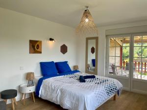 a bedroom with a large bed with blue pillows at Gîtes BEL'M in La Bresse