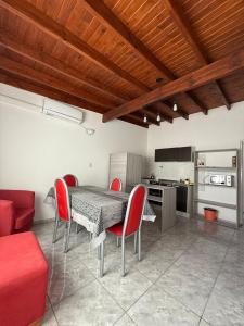 een eetkamer met een tafel en rode stoelen bij Sendero Patagonico in Las Grutas +21 foto's