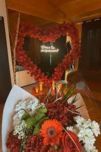 a heart made out of red and white flowers on a table at Domaine des Pins La cabane au bord de l'eau 