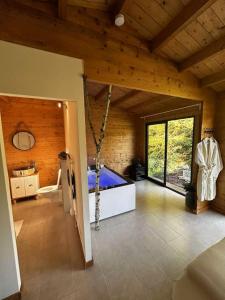 a large room with a large window in a wooden house at Domaine des Pins La cabane au bord de l'eau 