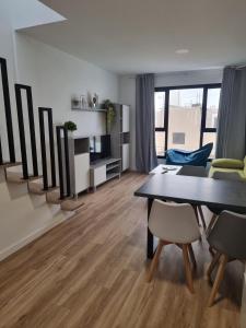 un soggiorno con tavolo da pranzo e sedie di Hoy Cotillo Apartments a Cotillo Altre 5 foto