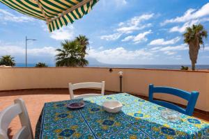 Una mesa y sillas con una mesa y vistas al océano. en Cavalluccio Marino Holiday, en Isola delle Femmine