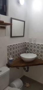 a bathroom with a sink and a toilet and a mirror at El Sol del Cuyo in El Cuyo +19 photos