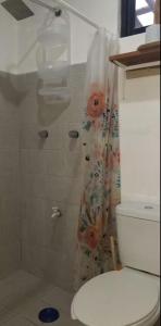 a bathroom with a shower with a toilet and a shower curtain at El Sol del Cuyo in El Cuyo