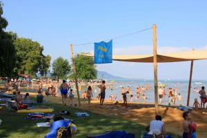 a crowd of people on a beach with a flag at Apartments in Balatongyörök 34590 in Balatongyörök