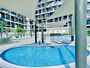 ein Schwimmbad vor einem großen Gebäude in der Unterkunft Modern 3BR Townhouse plus Maids The Gate, Masdar City in Abu Dhabi