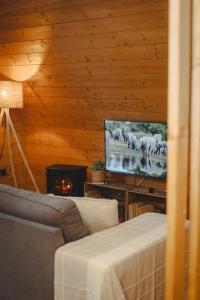 a living room with a couch and a television at Casas da Madrinha in Arcos de Valdevez