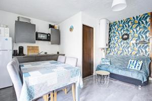 Una sala de estar con una mesa y una cocina. en Studio refait neuf ,4 personnes, terrasse, parking privé, climatisation, en Le Barcarès
