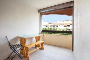 - Balcón con ventana, mesa y silla en Studio refait neuf ,4 personnes, terrasse, parking privé, climatisation, en Le Barcarès